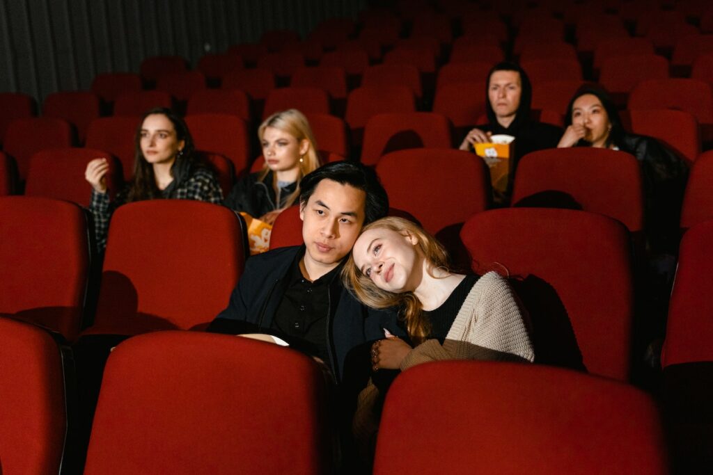 A group of people sitting in a theatre watching a movie.