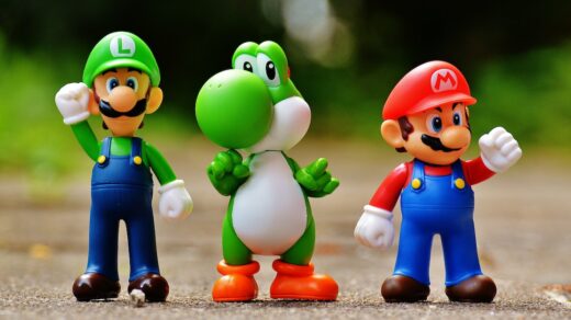 Luigi, Yoshi, and Mario figurines standing next to one another.