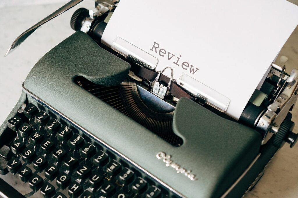 A critic's movie review being typed on a typewriter.
