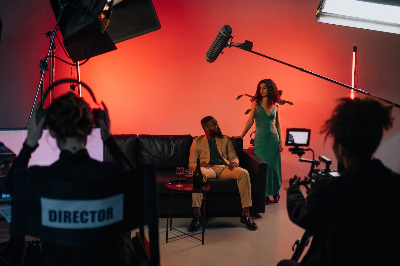 'a man sitting on a couch in front of a woman in a dress'