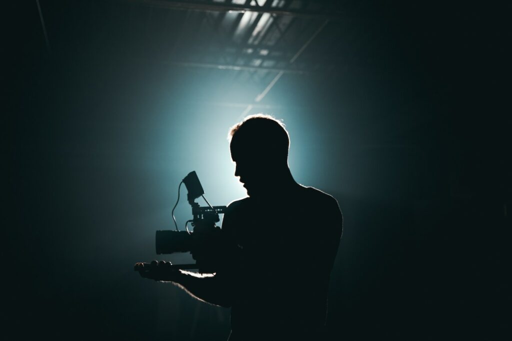 A filmmaker's silhouette against harsh bright lighting