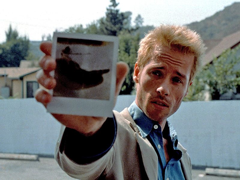 The main character form "Memento", Christopher Nolan's famous time travel movie, holding up a photograph.
