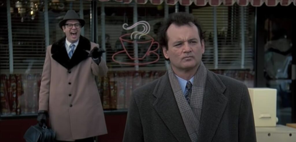 Billy Murray's character in "Groundhog Day" being laughed at outside of a cafe.