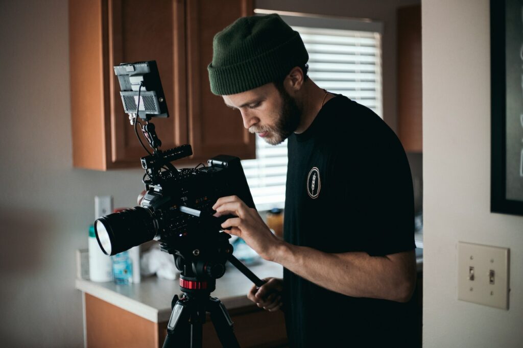 A man fiddling with his camera he is using for an interview.