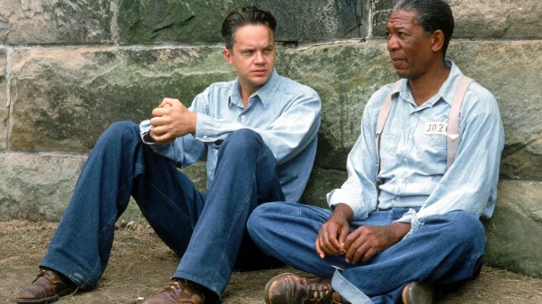 A scene from "The Shawshank Redemption" of Andy and Red sitting and chatting.