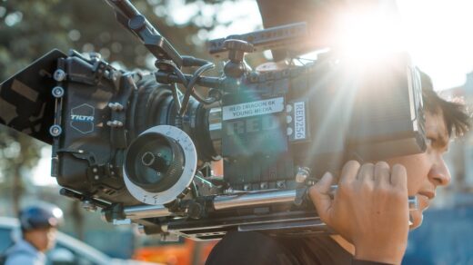 A man holding a camera over his shoulder.