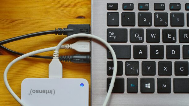 A laptop with a portable hard drive plugged into it.