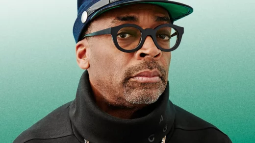 Spike Lee in a hat in glasses looking into the camera.
