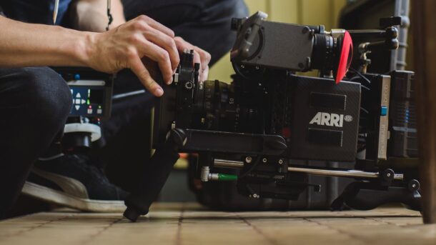 A person fiddling with a movie camera.