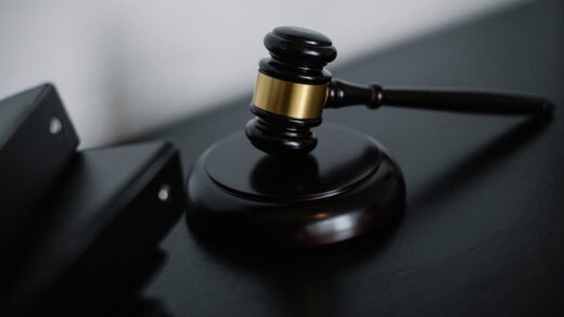 A gavel, a symbol of the legal system, resting upon a desk.