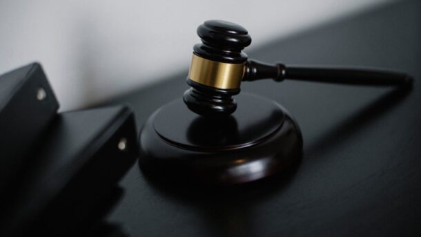 A gavel, a symbol of the legal system, resting upon a desk.